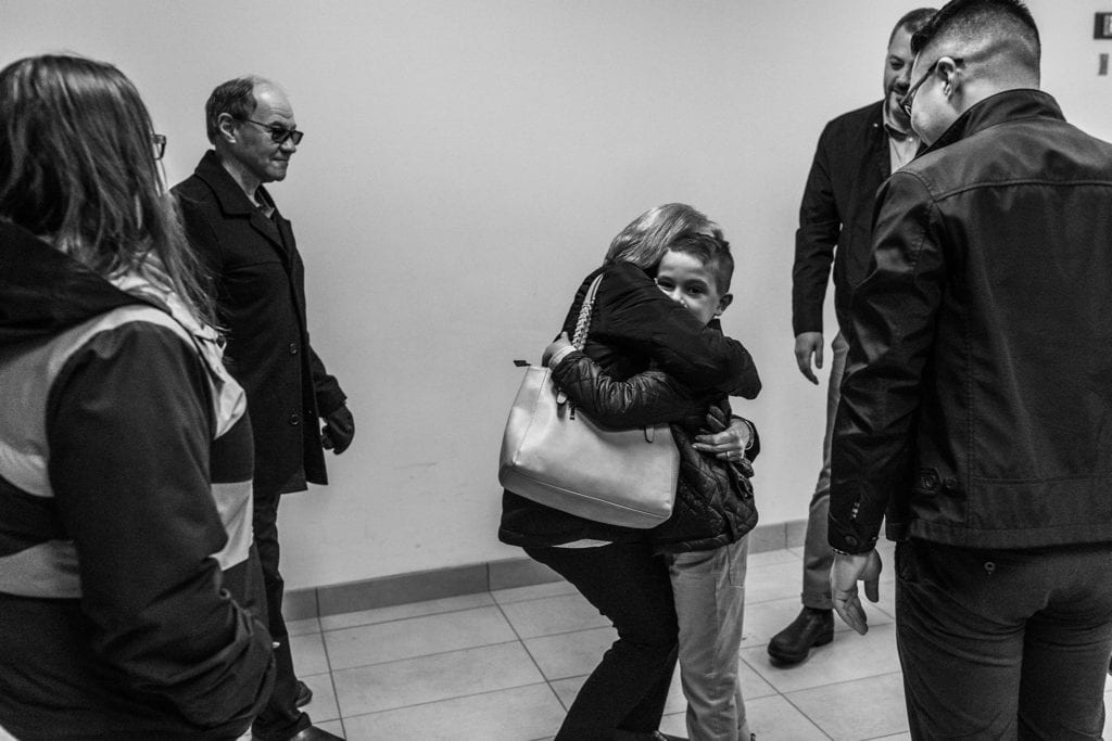hugs for young boy in hallway of cornwall courthouse on adoption day