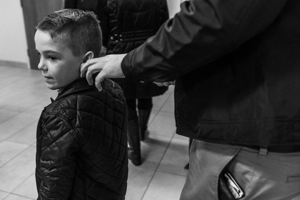 dad tweaks young boy's ear in hallway of cornwall courthouse on adoption day