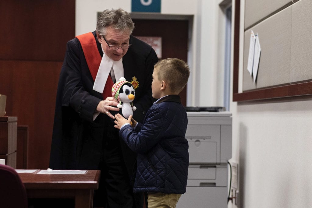 judge gives young boy stuffed penguin toy on Adoption day in Cornwall
