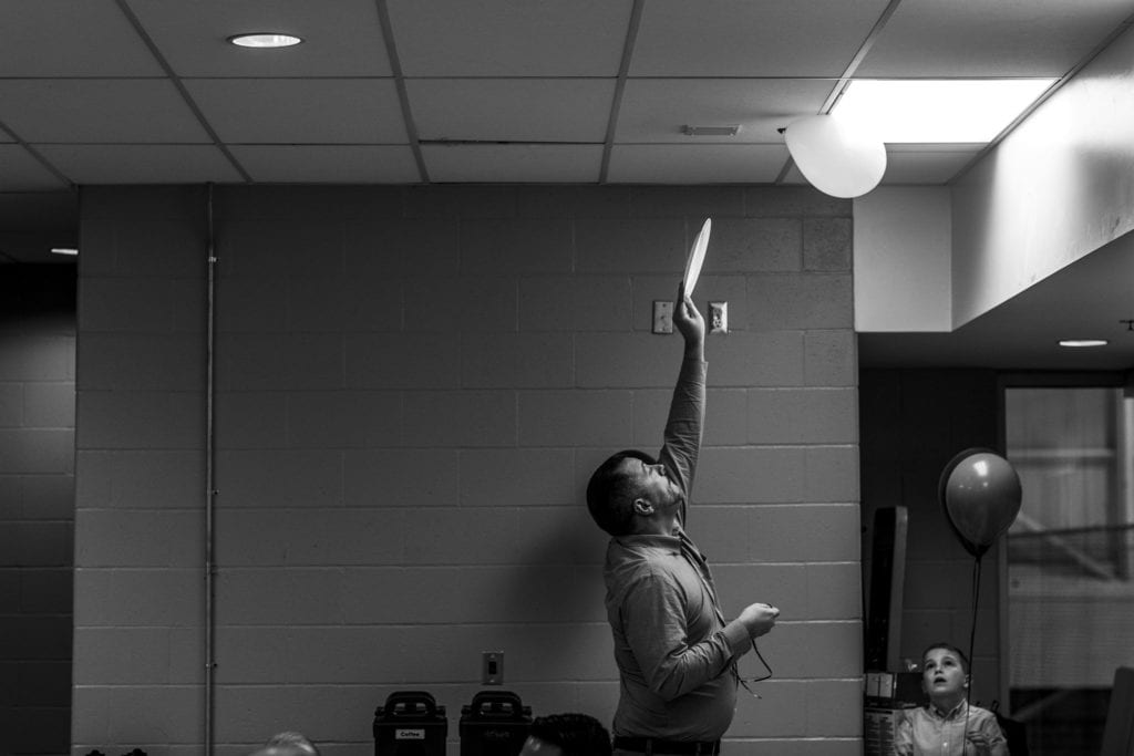 man moving balloon with young boy watching on Adoption day in Cornwall