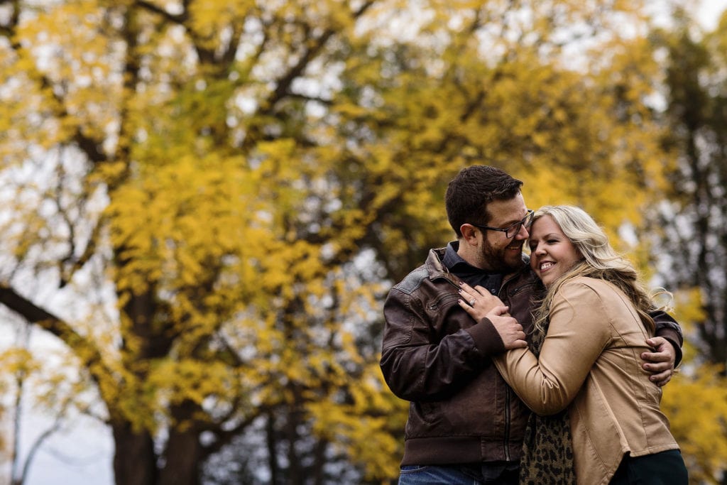couple laughing and embracing amidst fall strees at Williamstown Engagement Session