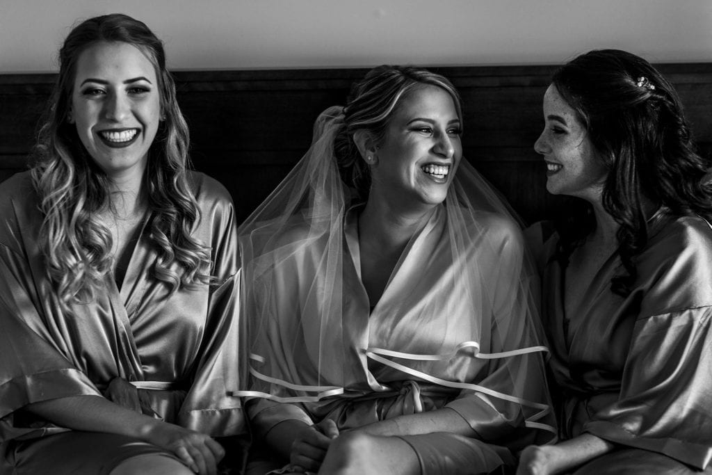 three girls in robes laugh together