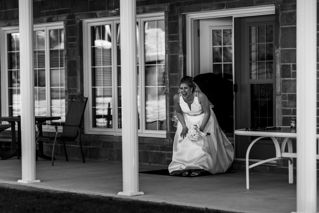 bride doubles over laughing after walking through doorway