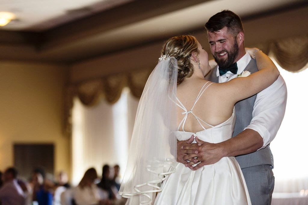 groom smiles at bride during first dance at River Rock Inn
