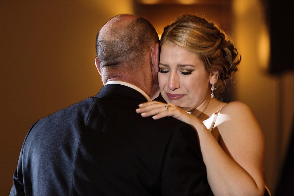 bride cries while dancing with father