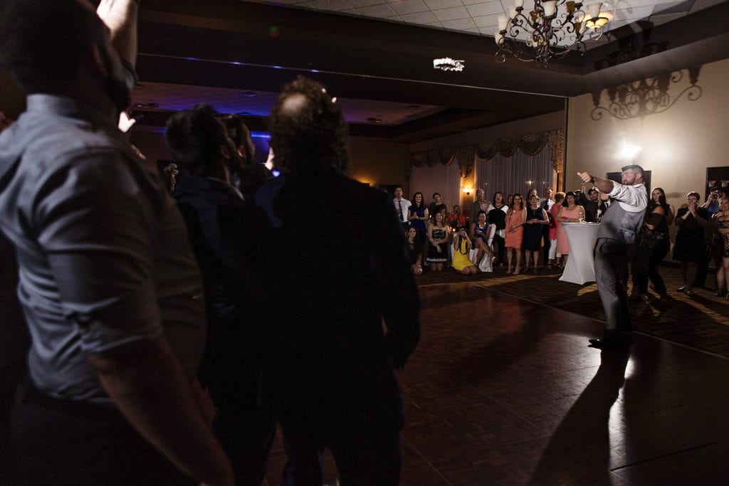 groom fires garter into crowd of men during Rockland wedding celebration