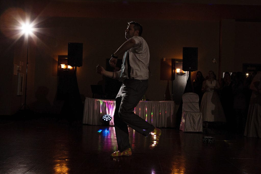 man on dancefloor along with light up socks in french tradition during Rockland wedding celebration