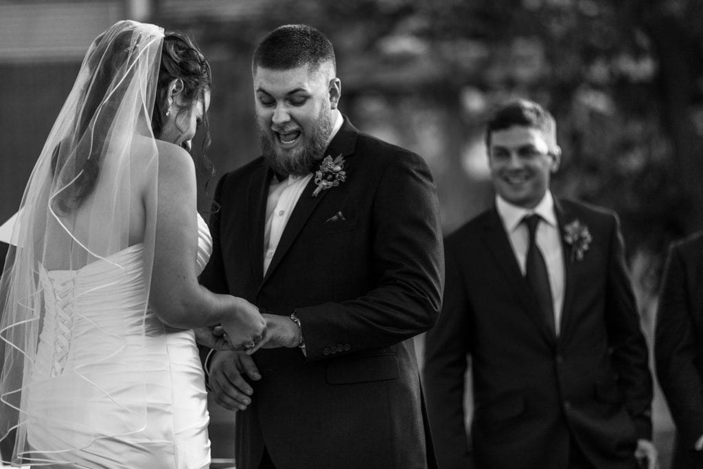 Groom reacts as bride forces ring on his finger during Ramada Inn Cornwall wedding ceremony