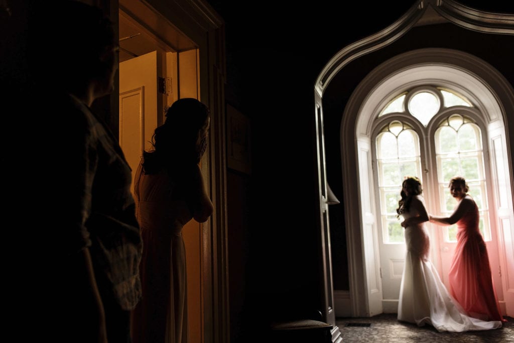 bridesmaid looks on in awe while bride gets dressed