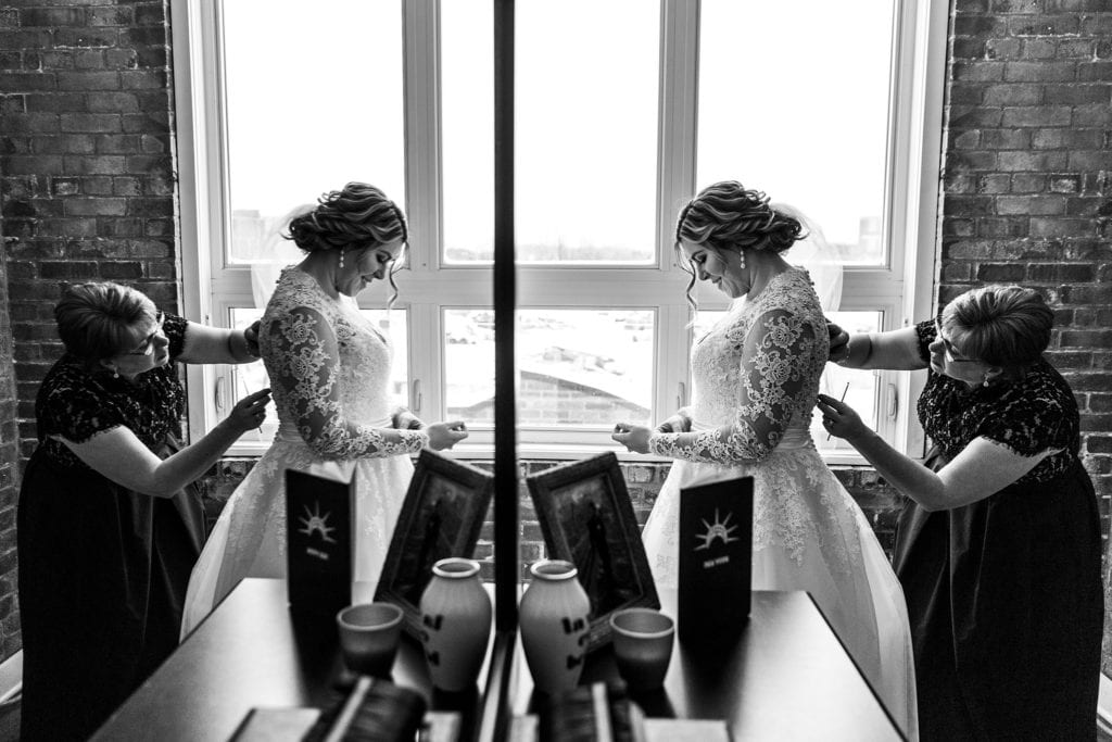 mother helps bride get ready before Cornwall church ceremony