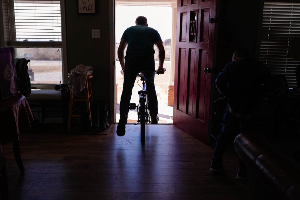 dad rides bike out of house