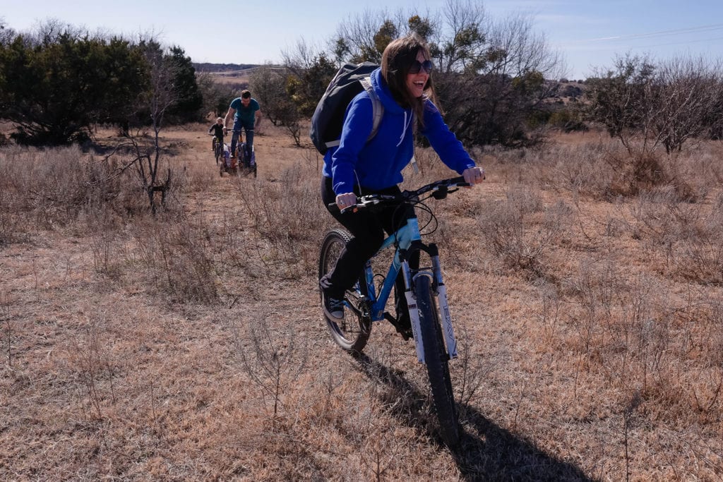 mom rides bike ahead of family