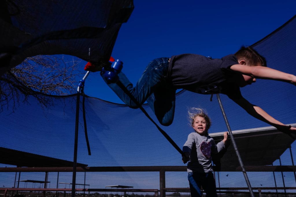 boy falls while jumping over rope held by girl on trampoline