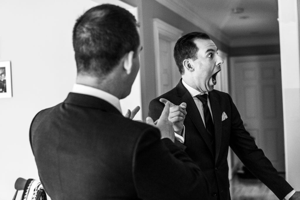 Orange Art Gallery wedding groomsman reacts in surprise and points at friend