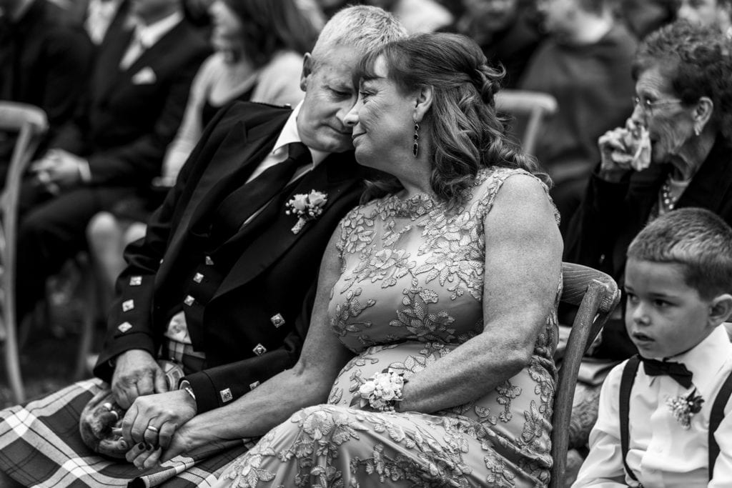 Mother and father of the bride lean heads together during Maxville Fairgrounds wedding ceremony
