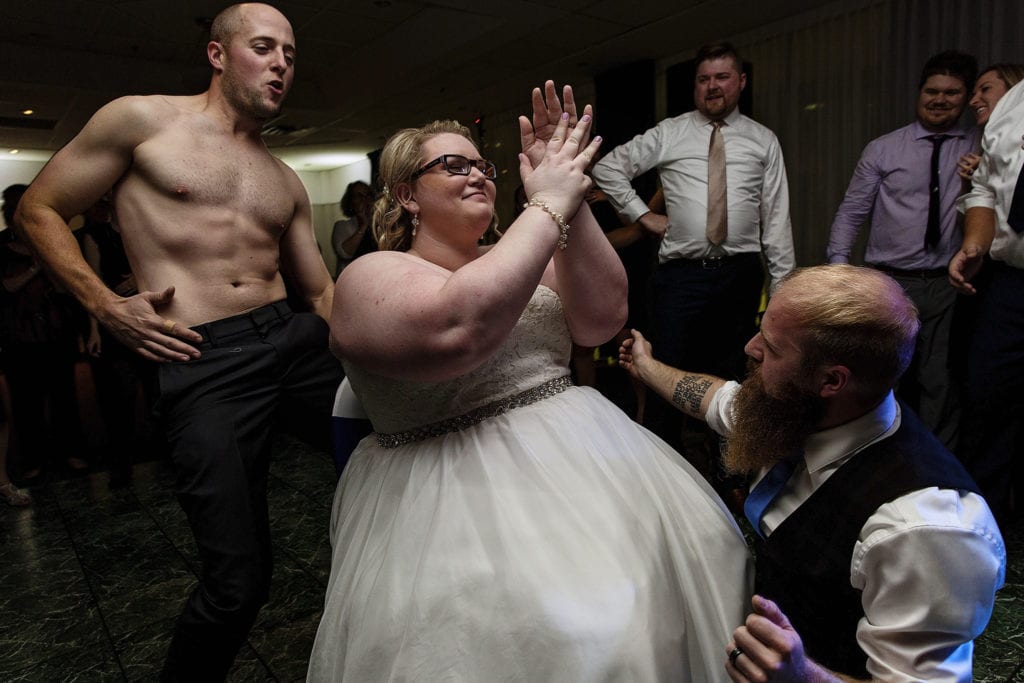 half naked man and other guests dance for bride during NAV Centre wedding reception