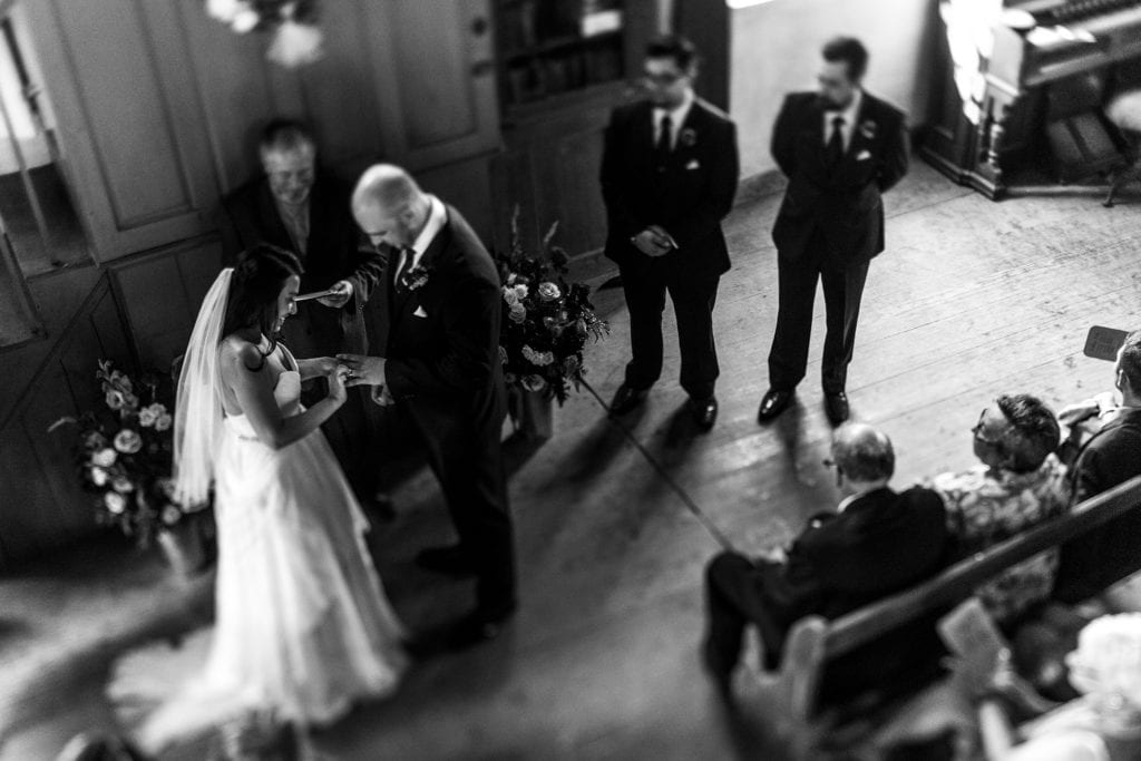 bride and groom exchange rings during wedding ceremony in tiny Prince Edward County church