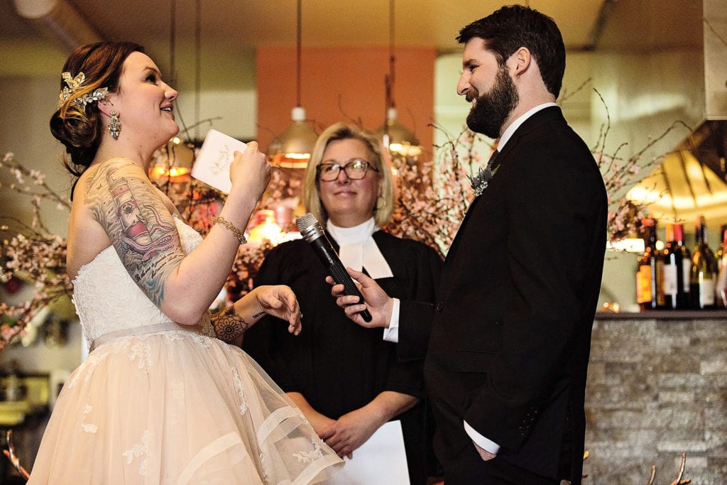 bride flaps paper in front of face while trying not to cry