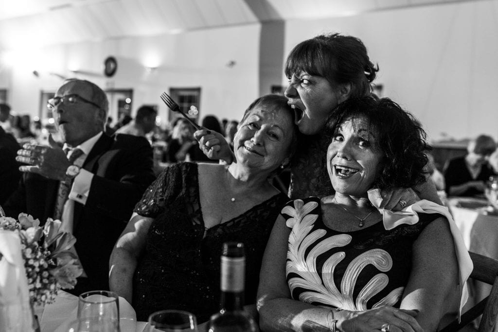 Woman reacts as food is stolen off her fork during portrait with her sisters