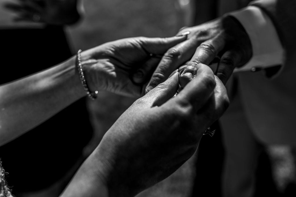 Bride slips ring on grooms finger during NAV Centre wedding