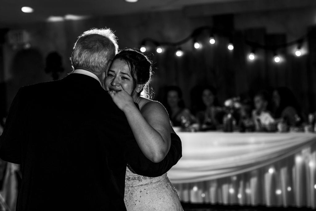 bride cries while dancing with father