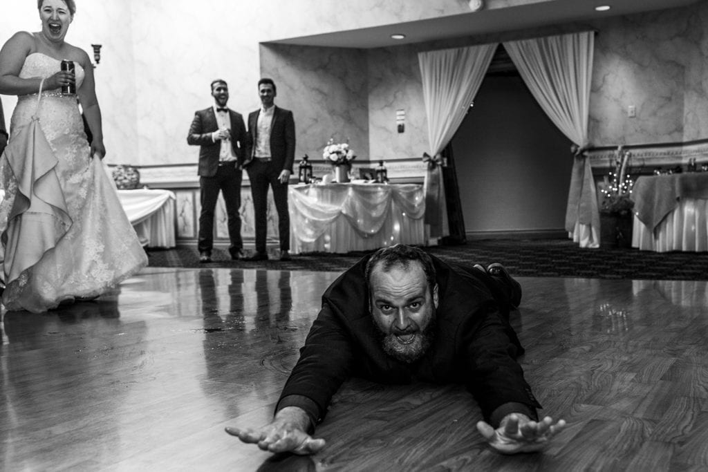 wedding guest slides across Best Western Cornwall dance floor on stomach as shocked bride laughs in background