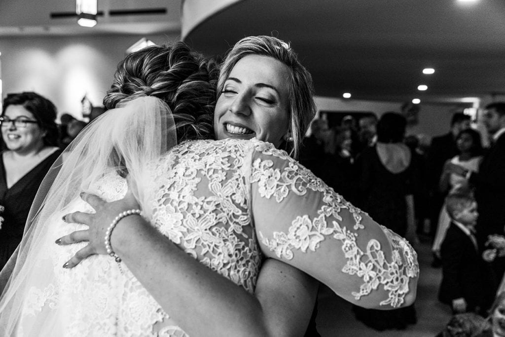 woman hugs bride after wedding ceremony