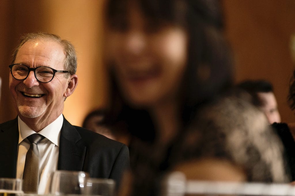 mother and father of the groom laugh during wedding toasts