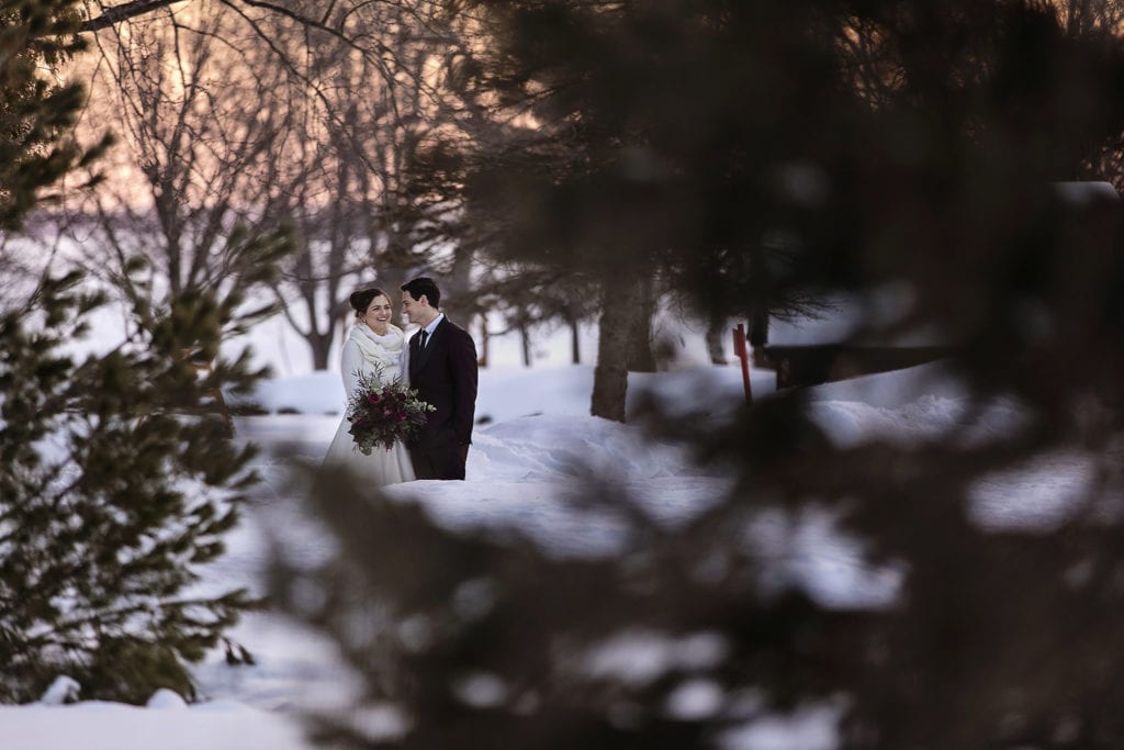 bride and groom stand together in the snow at Fairmont Chateau Montebello