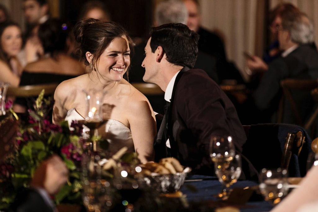 bride and groom smile while leaning toward each other