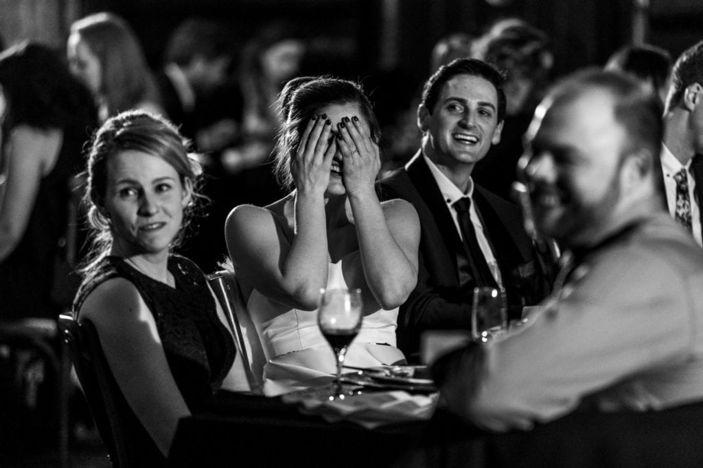 bride covers her face during speeches