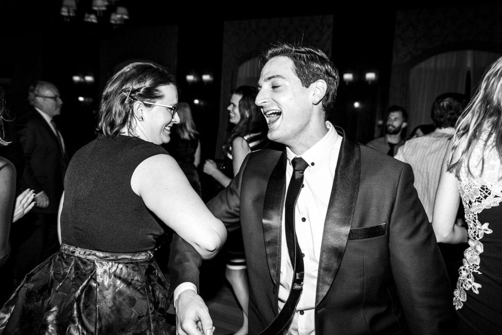 groom links arms on dancefloor with Winter Chateau Montebello Wedding guest