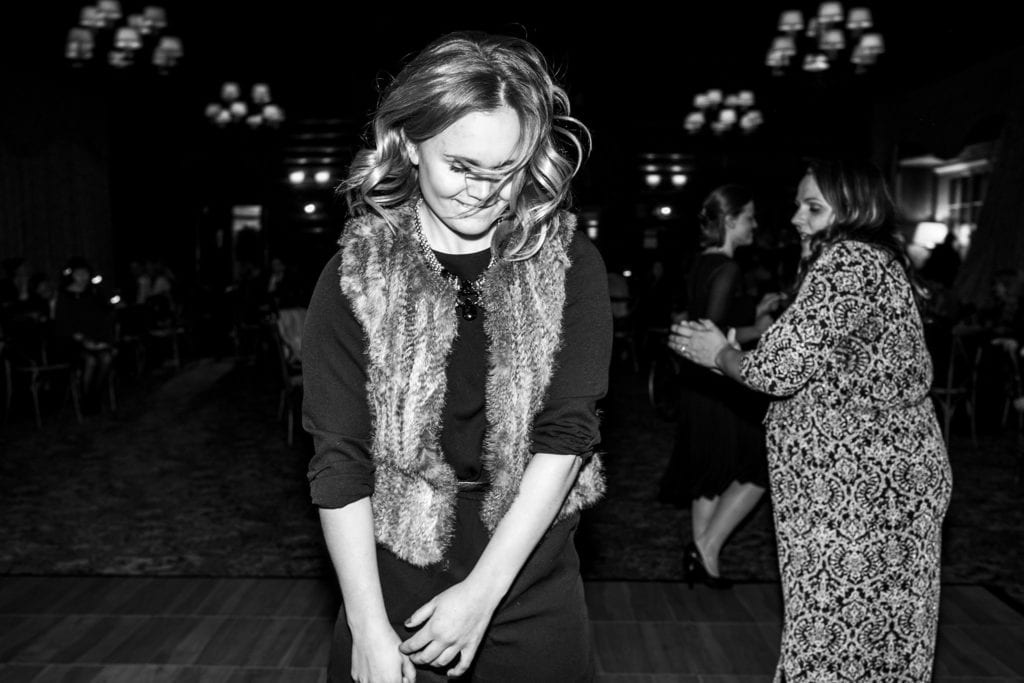 woman on dance floor in fur vest with hair bobbing in face