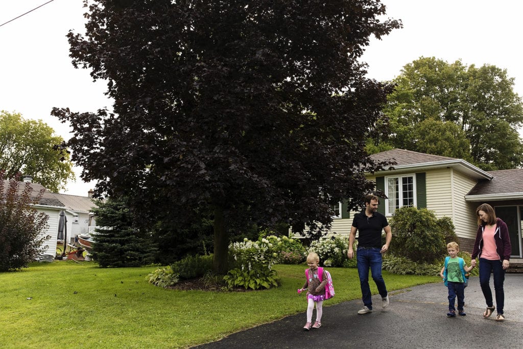 family with two children walk down driveway