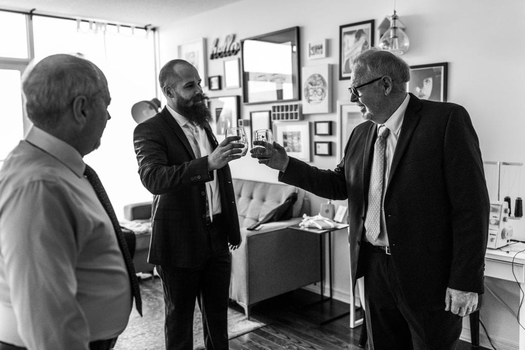 groom toasts with father-in-law in apartment