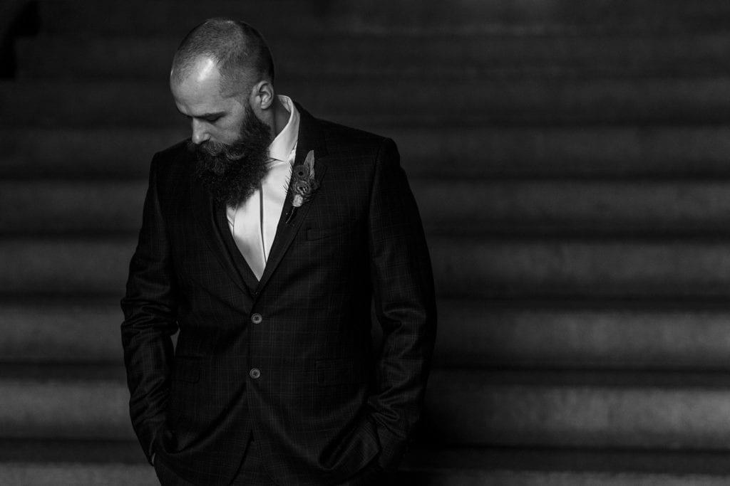 groom looks to the side while he waits for bride to join him