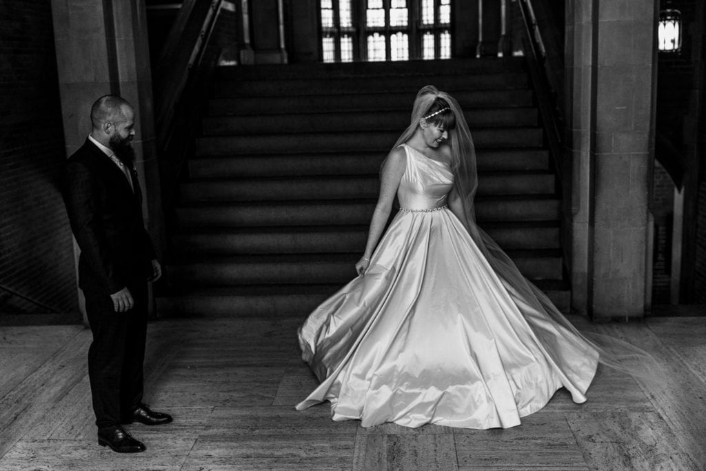 bride twirls in her dress in front of groom 