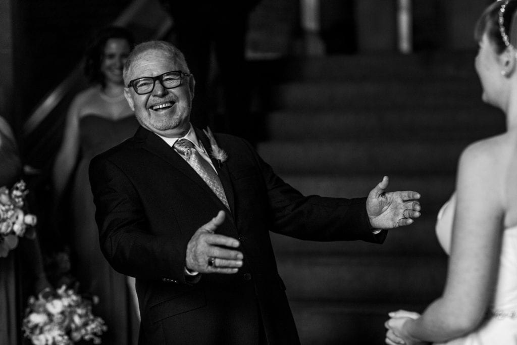 bride's father smiles widely and reacts with joy