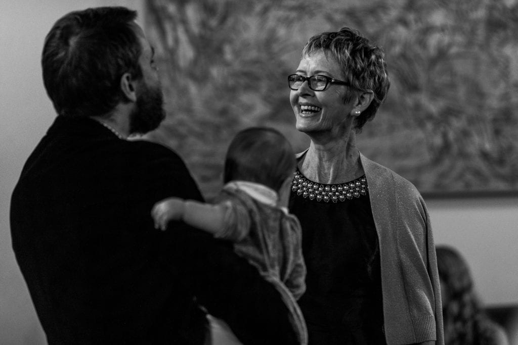 woman smiles at man holding baby