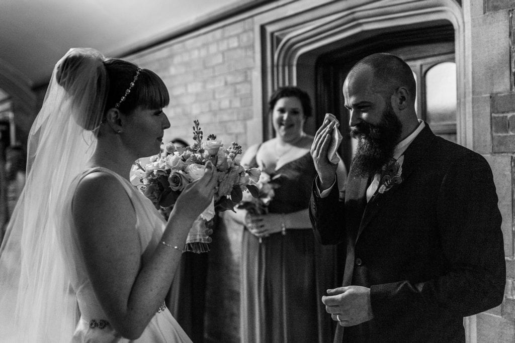 bride and groom wipe eyes after exiting wedding ceremony