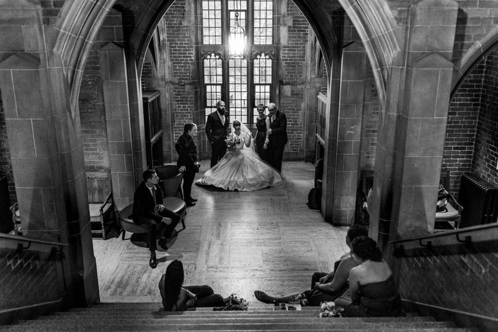family and wedding party loiter in stairway at Hart House during family portraits