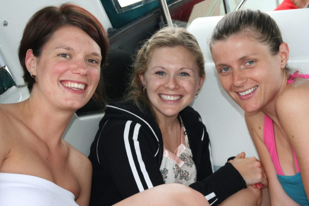 one redhead, one blonde, one brunette sit close together