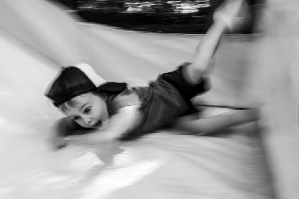motion shot of boy sliding inside bouncy house