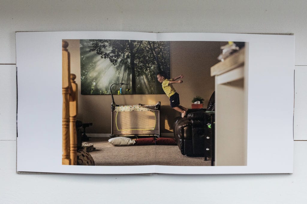 documentary family photography album pages featuring boy leaping off of couch