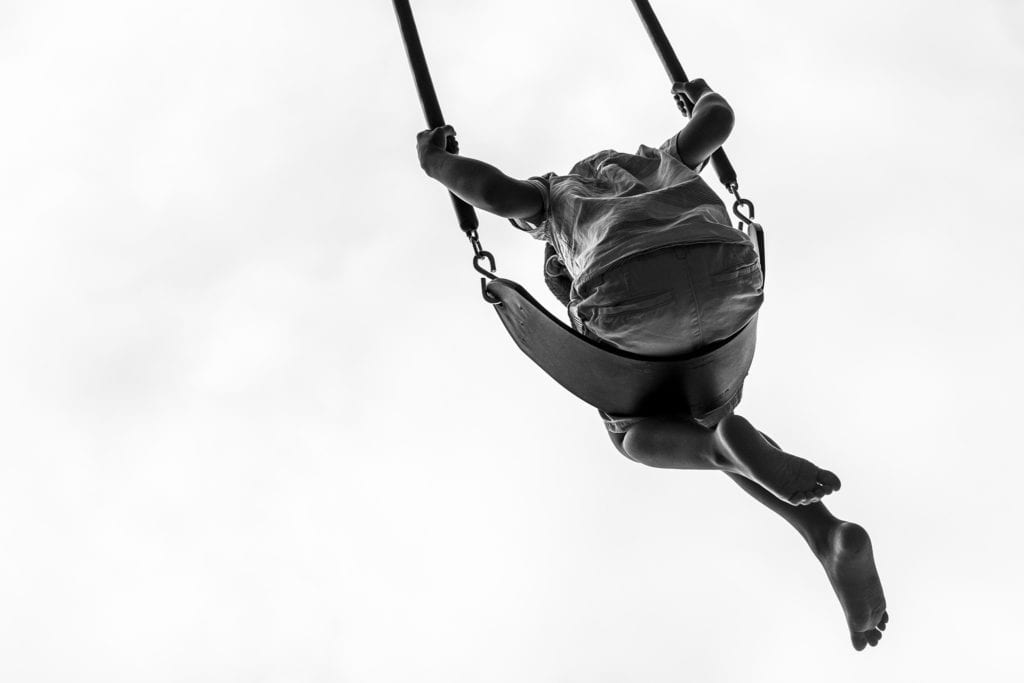 boy swings high overhead on swing