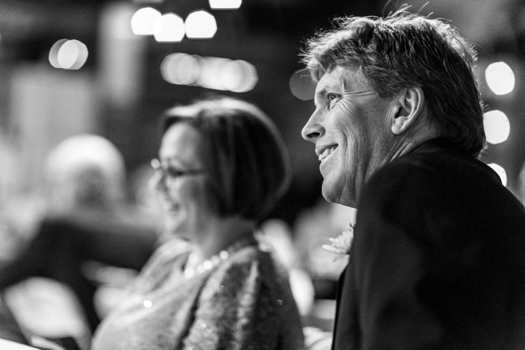 smiling mother and father in wedding attire