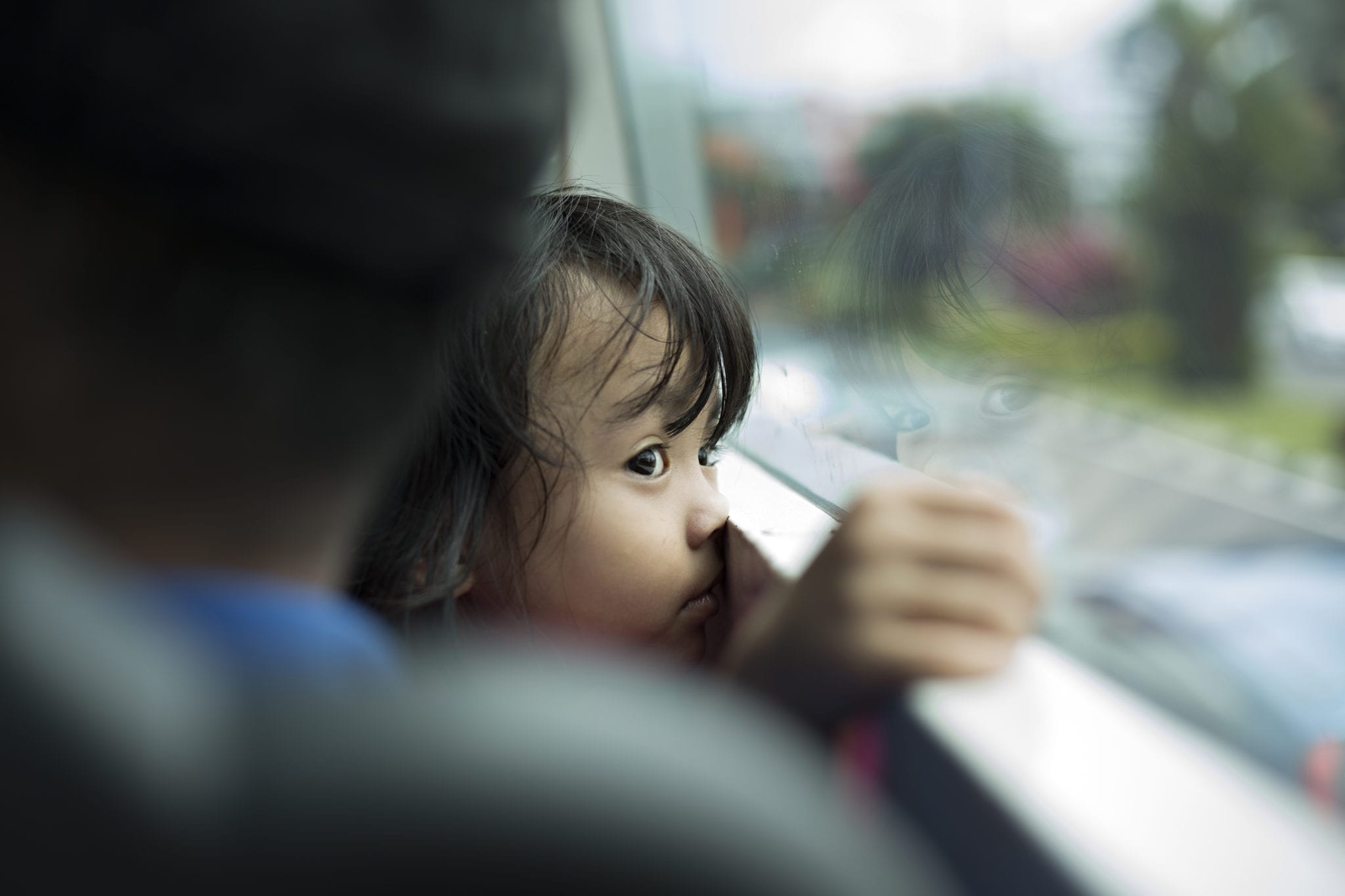 little girl looking out bus window