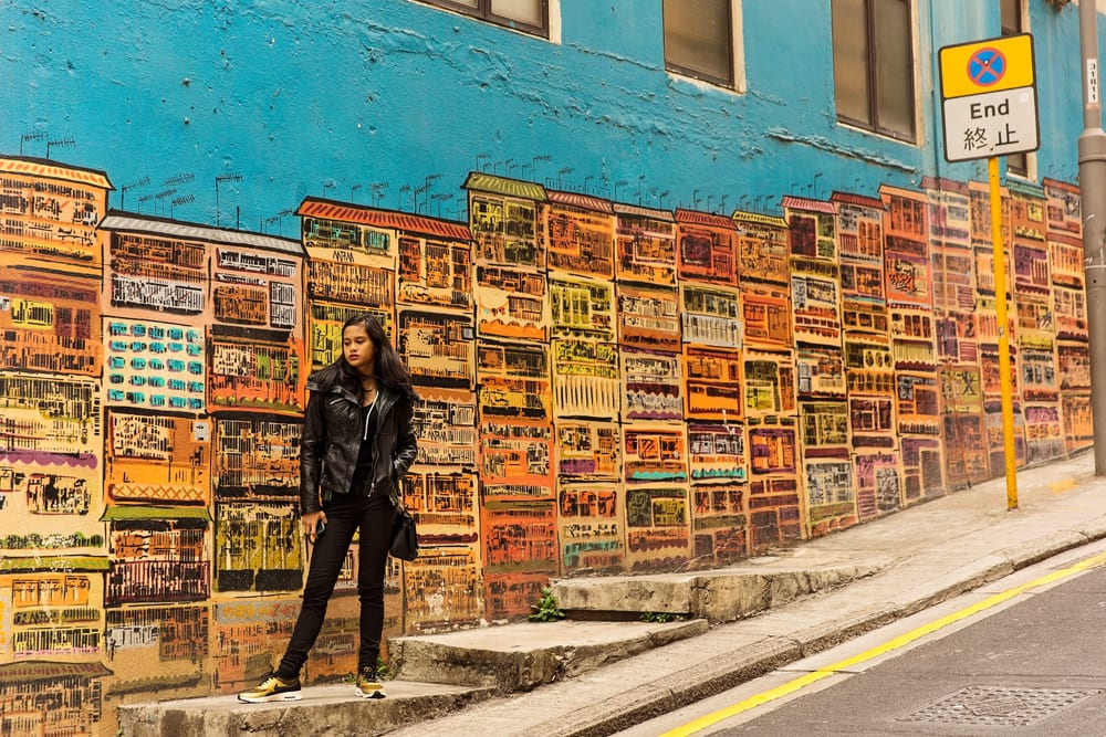 girl standing in front of mural