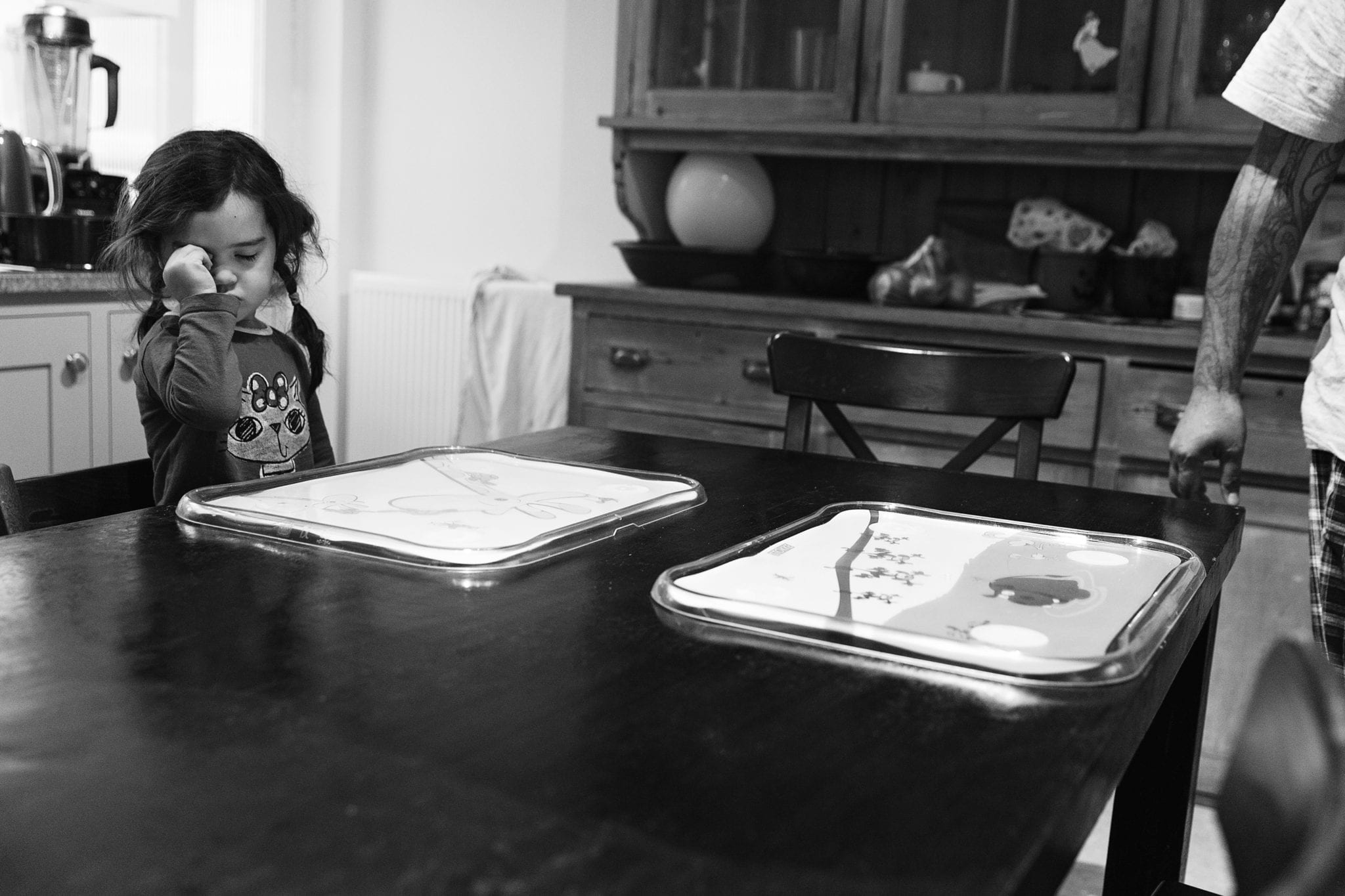 girl sitting at kitchen table during session with london family photographer
