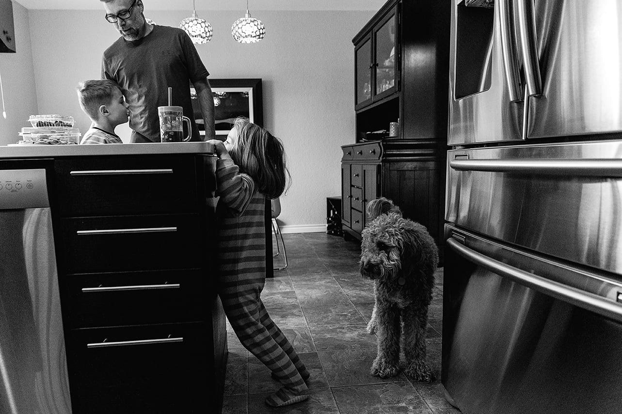 girl looks at juice while dog looks at her